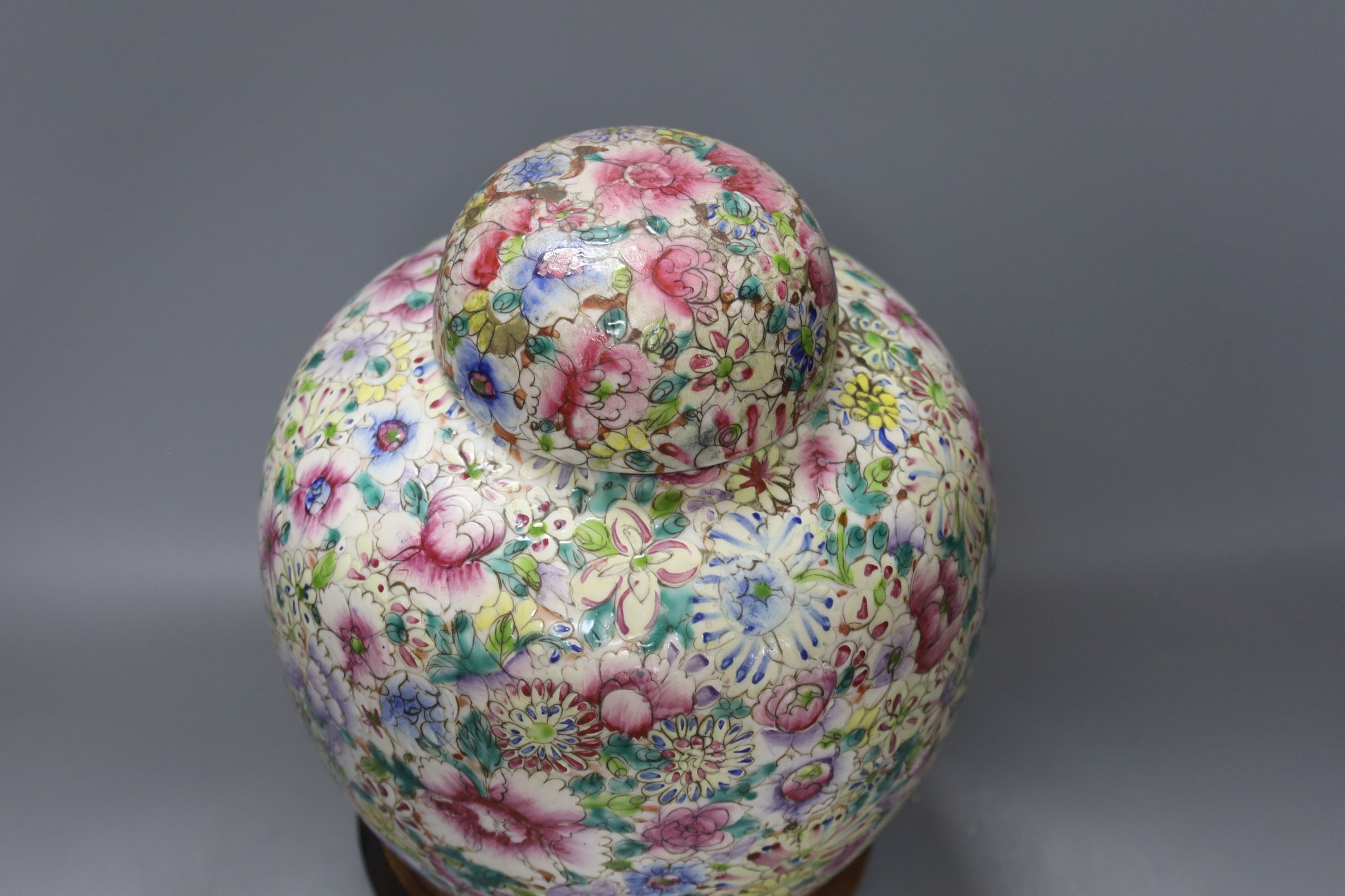 A Chinese thousand flower famille rose jar and cover, early 20th century, wood stand 28cm